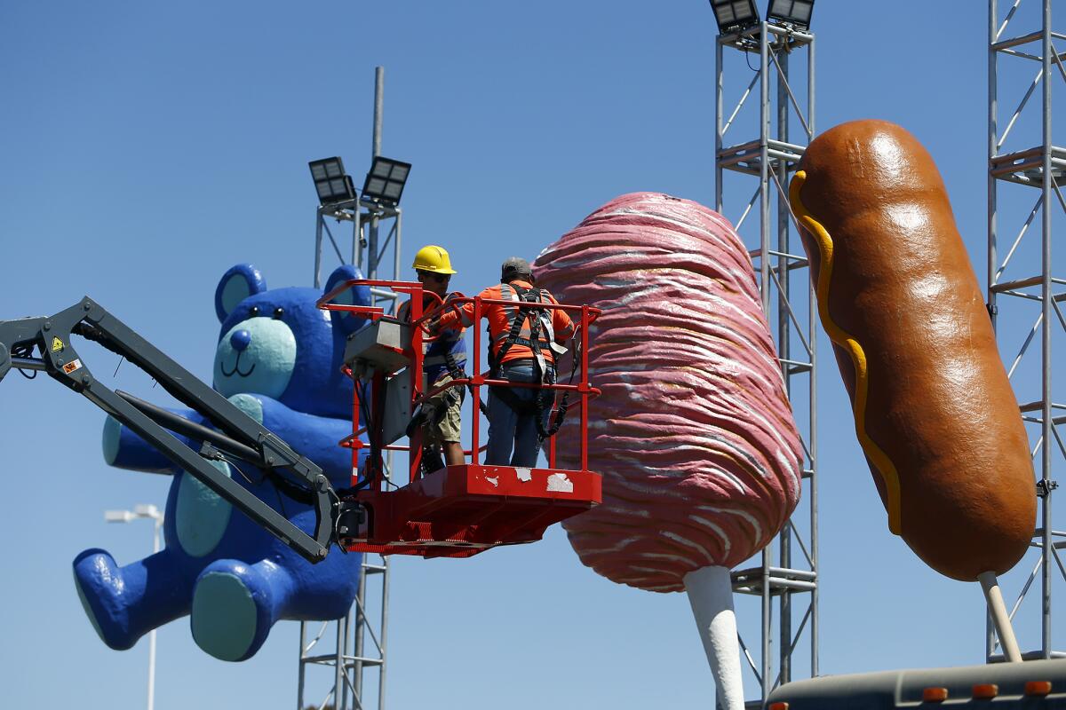 Workers Friday prepare for the Orange County Fair, coming to the fairgrounds in Costa Mesa July 15 through Aug. 14.