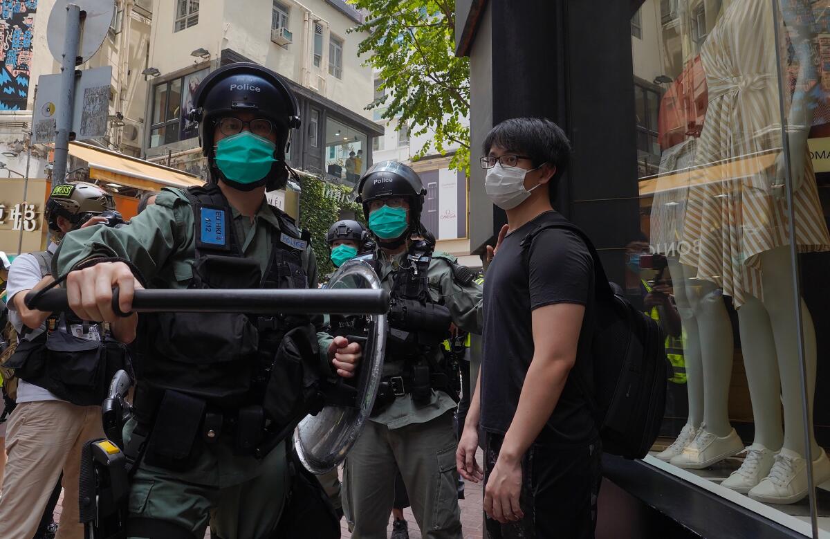 Riot police form a line May 27 as they check pedestrians gathered in the Central district of Hong Kong.