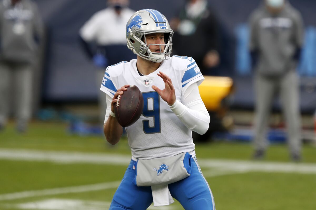 Quarterback Matthew Stafford holds the ball on the field during a game.