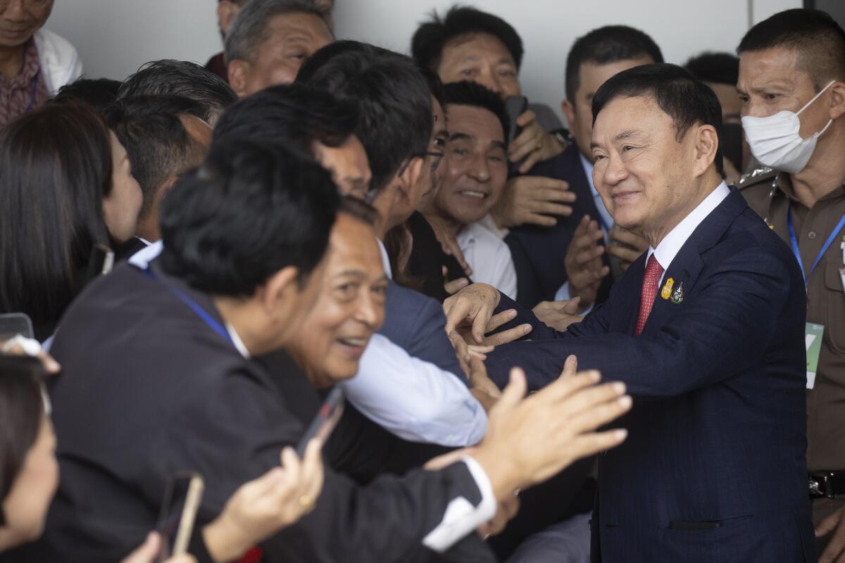 Former Thai Prime Minister Thaksin Shinawatra being greeted by supporters