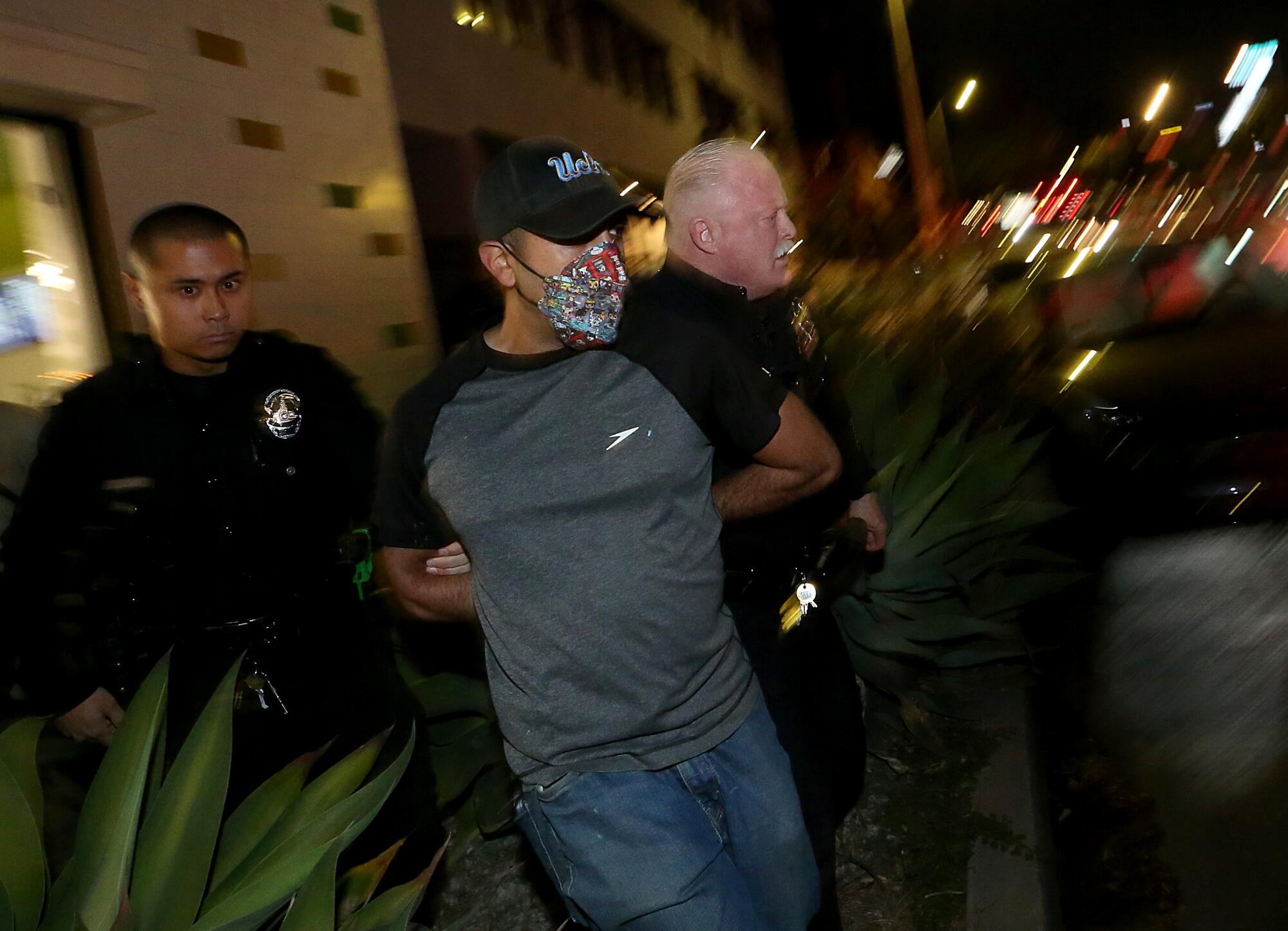 A pro-Palestine supporter is detained by police outside The Museum of Tolerance in Los Angeles.