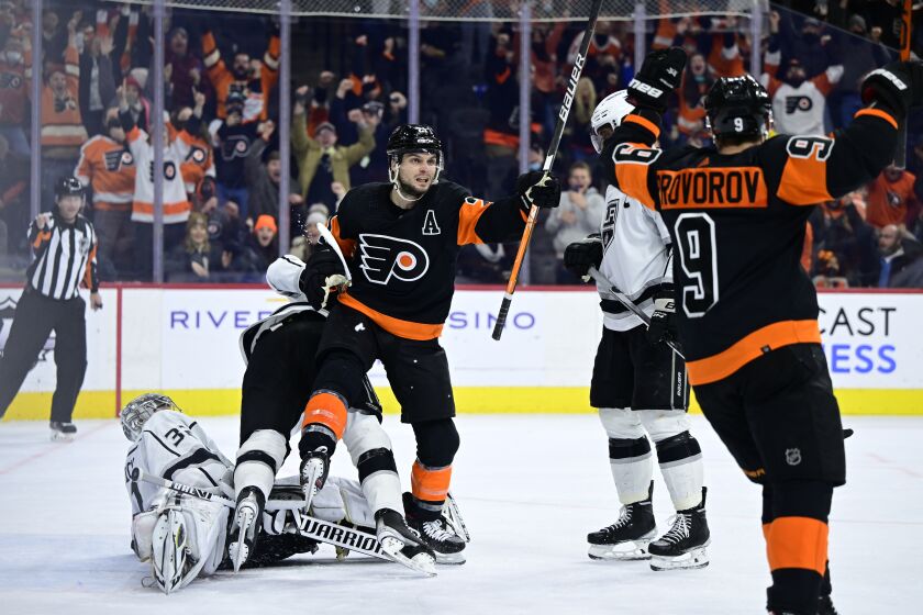 The Flyers' Scott Laughton, center, celebrates after scoring the winning goal past Kings goalie Jonathan Quick.