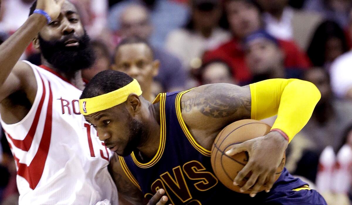 Rockets guard James Harden draws a charging foul from Cavaliers forward LeBron James in the second half Sunday.