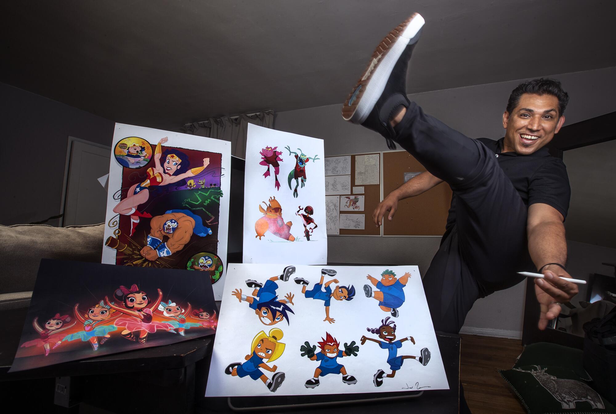 Artist Jose Zelaya is photographed next to some of his portfolio pieces at his home in Burbank.