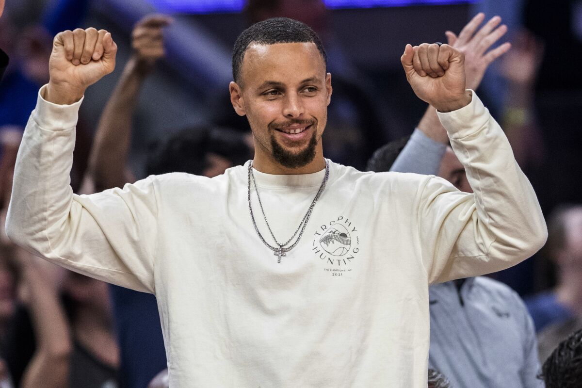 Golden State Warriors guard Stephen Curry reacts from the bench during the third quarter of the team's NBA basketball game against the Los Angeles Lakers in San Francisco on Thursday, April 7, 2022. (Stephen Lam/San Francisco Chronicle via AP)