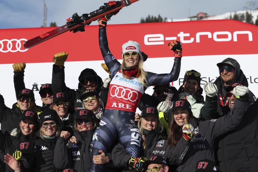 The winner United States' Mikaela Shiffrin celebrates with the team after an alpine ski, women's World Cup slalom, in Are, Sweden, Saturday, March 11, 2023. (AP Photo/Alessandro Trovati)