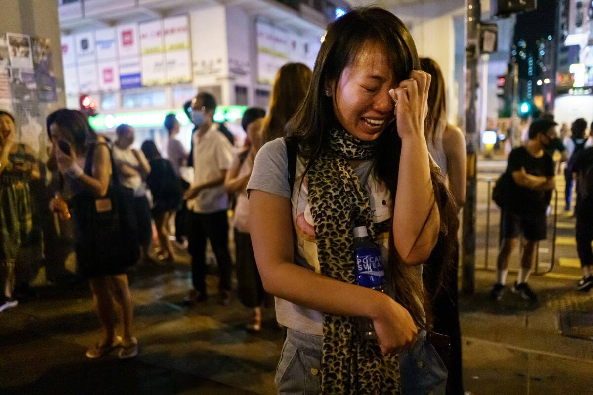 Pino Tong cries Sept. 11 as she and others pay respects to those injured in a clash with police in Hong Kong.

