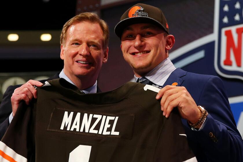 Former Texas A&M quarterback Johnny Manziel poses with NFL Commissioner Roger Goodell after being selected by the Cleveland Browns in the NFL draft.