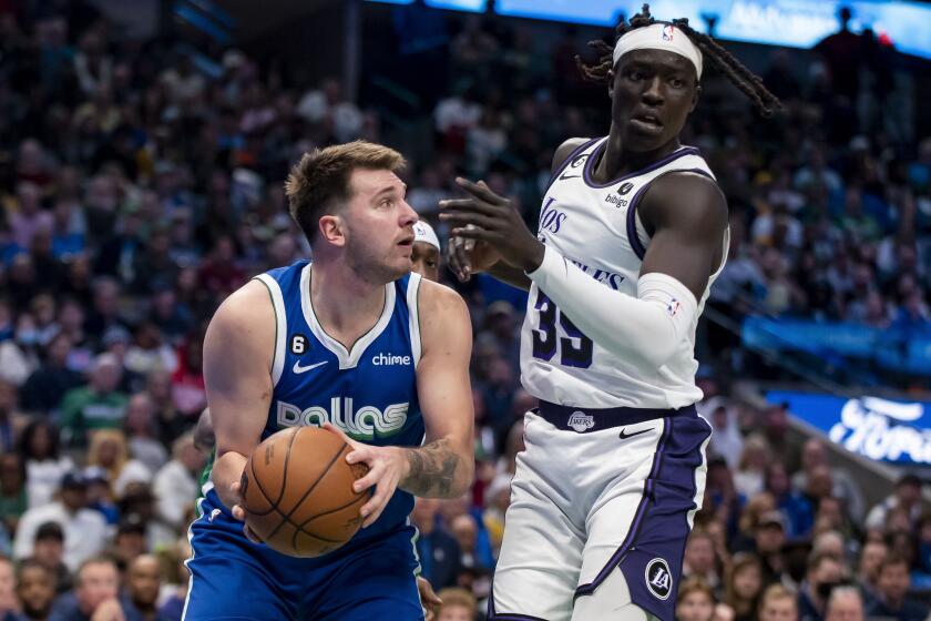Dallas Mavericks guard Luka Doncic fakes out Los Angeles Lakers forward Wenyen Gabriel in the second half of an NBA basketball game in Dallas, Sunday, Dec. 25, 2022. (AP Photo/Emil T. Lippe)