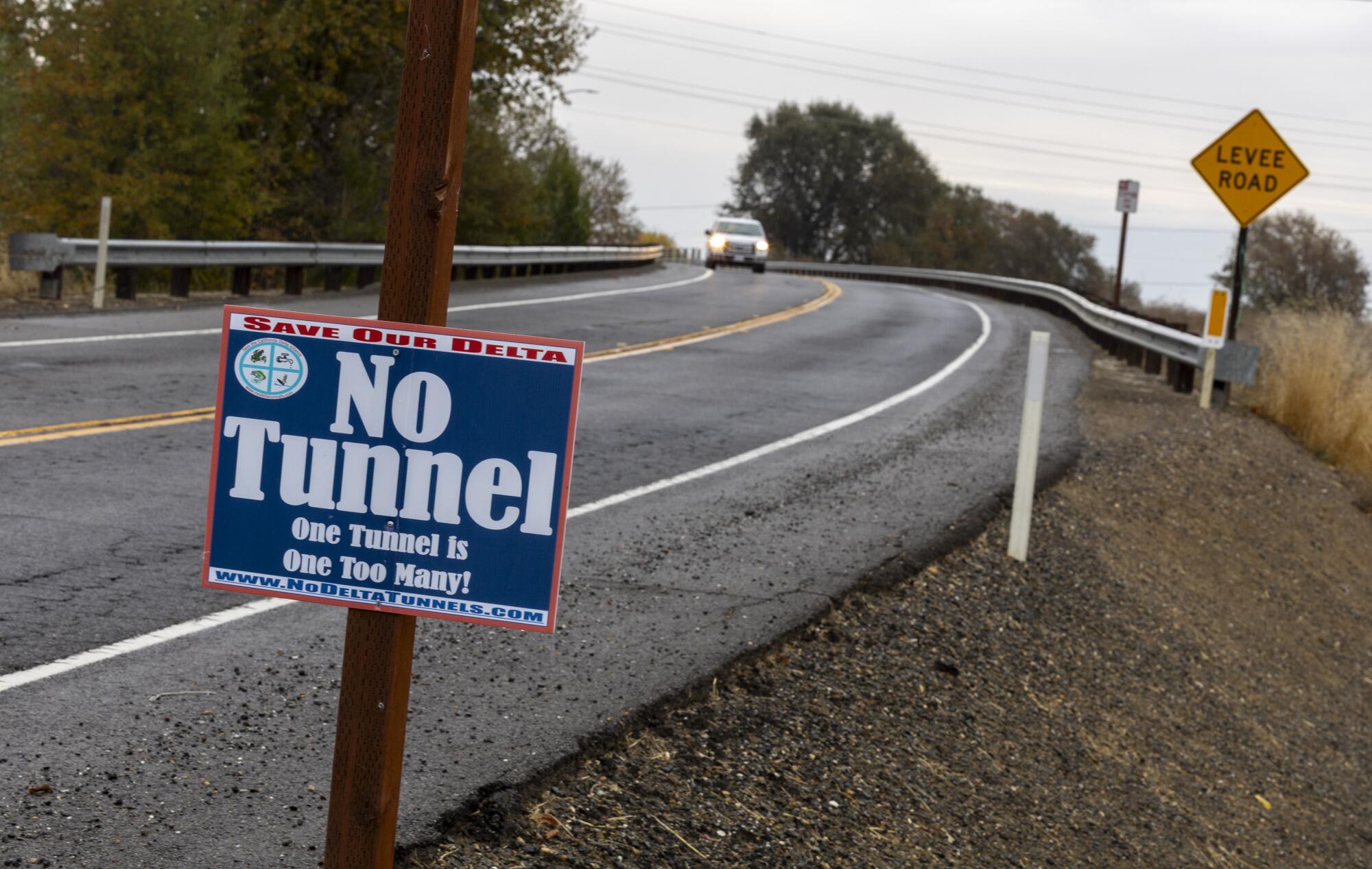 A sign reading "No Tunnel" stands at a curve on a rural road.