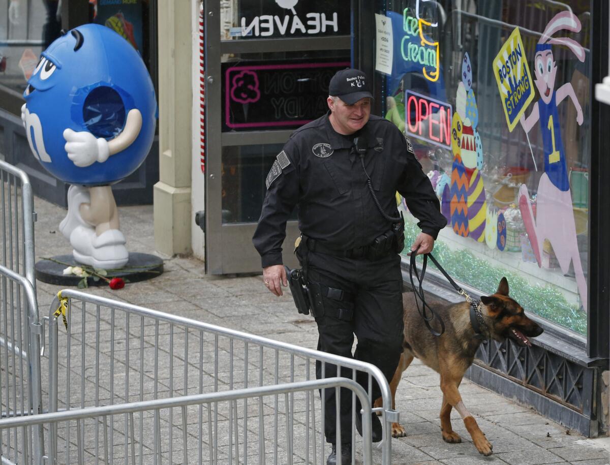 A police officer and police dog patrol Boylston Street near the site of the Boston Marathon finish line on Tuesday.