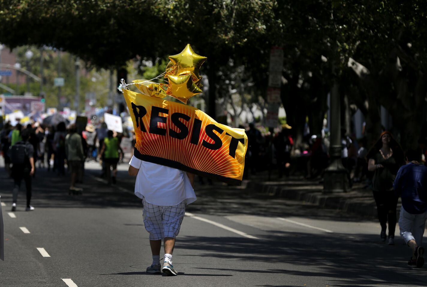 A protester carries a "Resist" banner toward the end of the impeachment march through downtown Los Angeles.