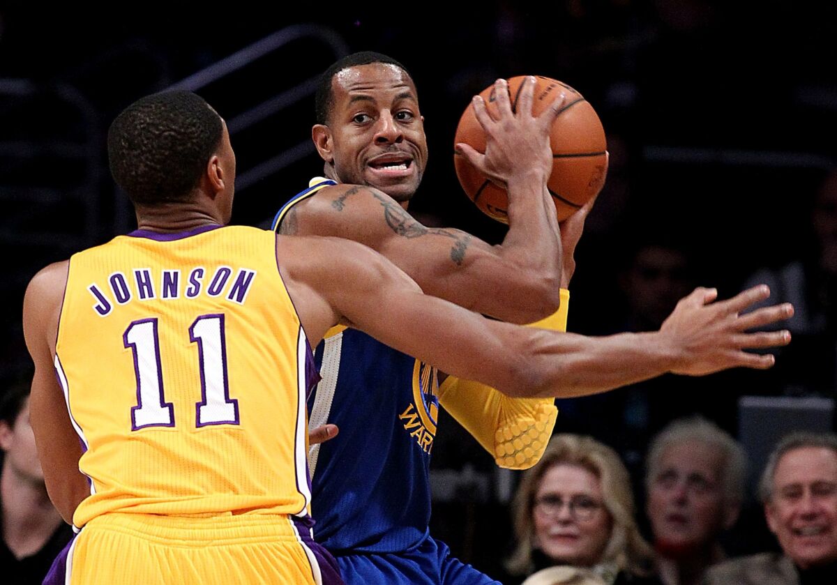 Lakers forward Wesley Johnson applies defensive pressure against Warriors forward Andre Iguodala in the first half Friday night at Staples Center.