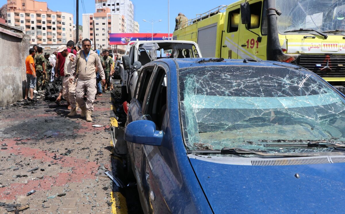 Security personnel prepare to remove a vehicle at the site of a deadly car bomb attack that targeted two senior government officials, who survived, security officials said, in the port city of Aden, Yemen, Sunday, Oct. 10, 2021. Aden has been the seat of the internationally recognized government of President Abed Rabbo Mansour Hadi since the Iranian-backed Houthi rebels took over the capital, Sanaa, triggering Yemen’s civil war. (AP Photo/Wael Qubady)