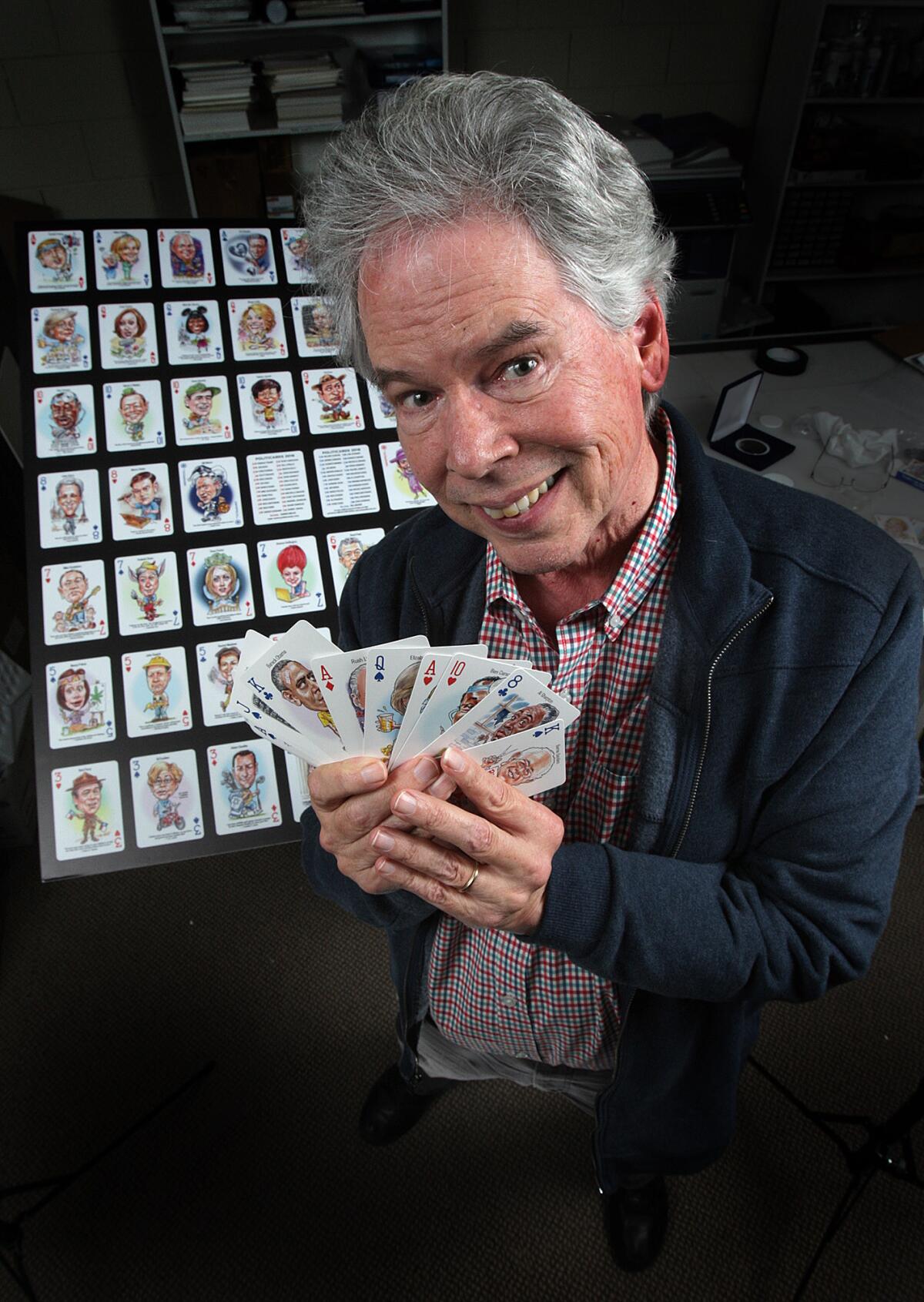 Peter Green, who has created Politicards since 1972, holds his newest edition of playing cards with childlike caricatures of current players in the election landscape in his Glendale office.
