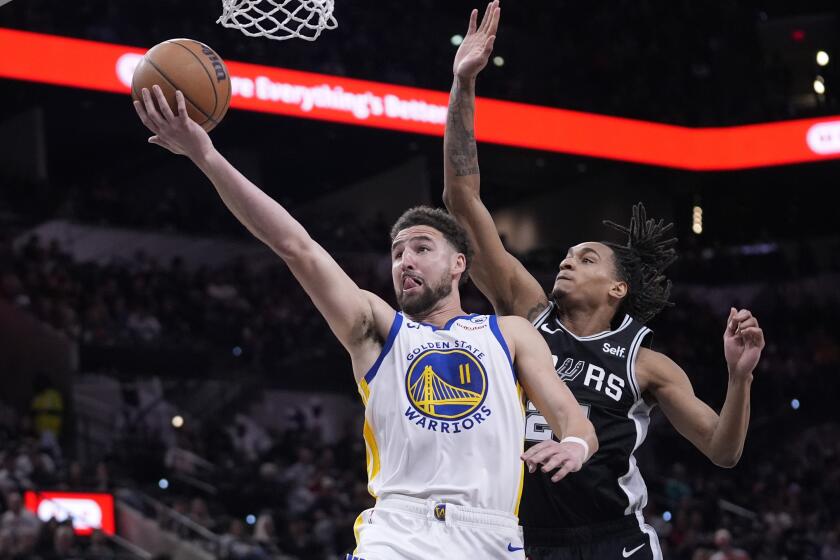 FILE - Golden State Warriors guard Klay Thompson (11) scores past San Antonio Spurs guard Devin Vassell, right, during the second half of an NBA basketball game in San Antonio, Monday, March 11, 2024. Klay Thompson is moving on from the Golden State Warriors, with the four-time league champion agreeing to join the Western Conference champion Dallas Mavericks and change franchises for the first time in his 13-year NBA career, two people with knowledge of the decision said Monday, July 1, 2024.(AP Photo/Eric Gay, File)