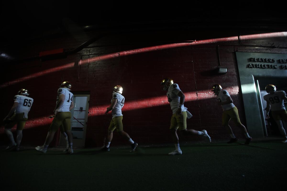 Notre Dame players head to the Coliseum field to warm up before playing USC 