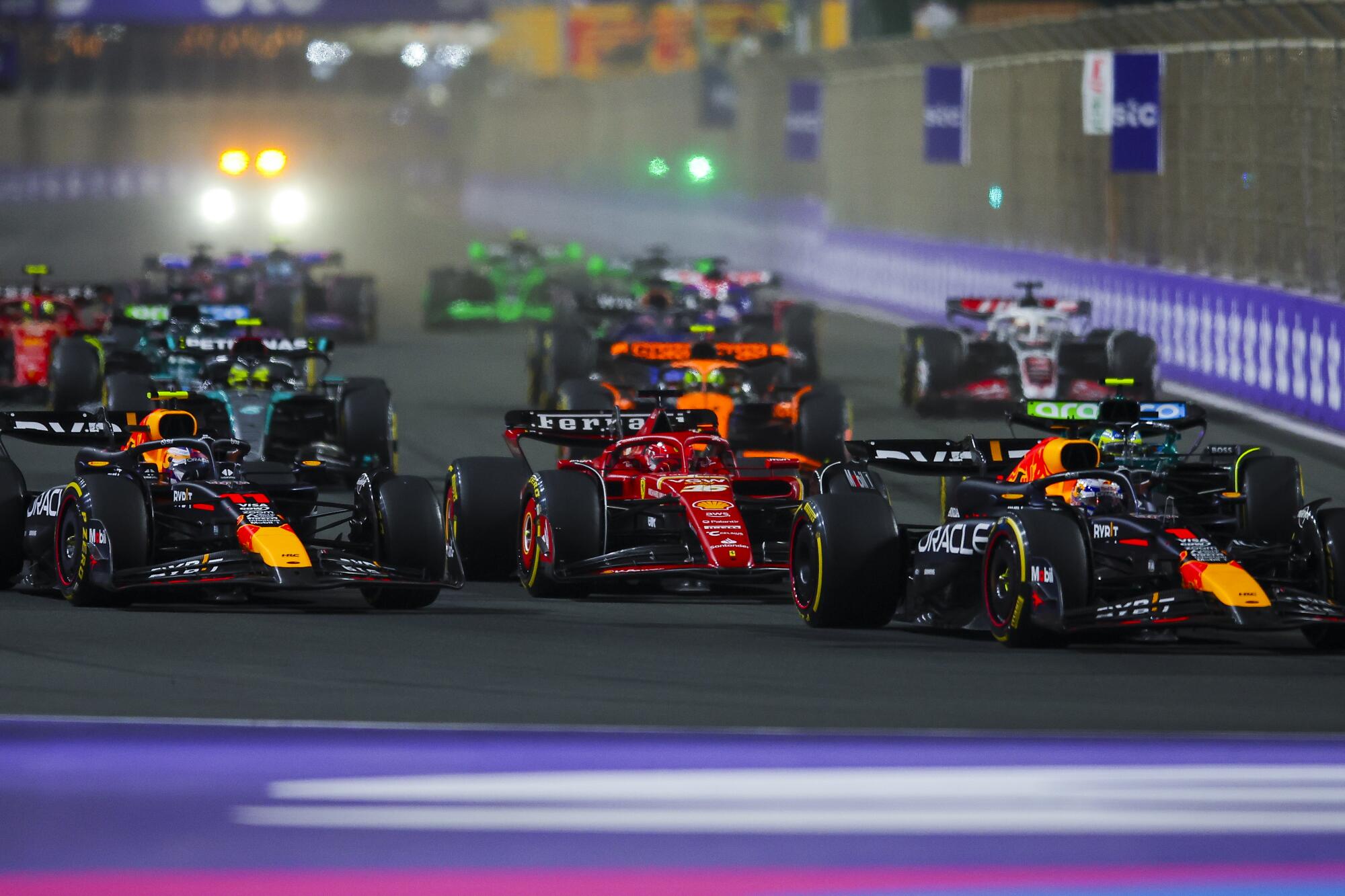 Formula One drivers race in close quarters on a track. 
