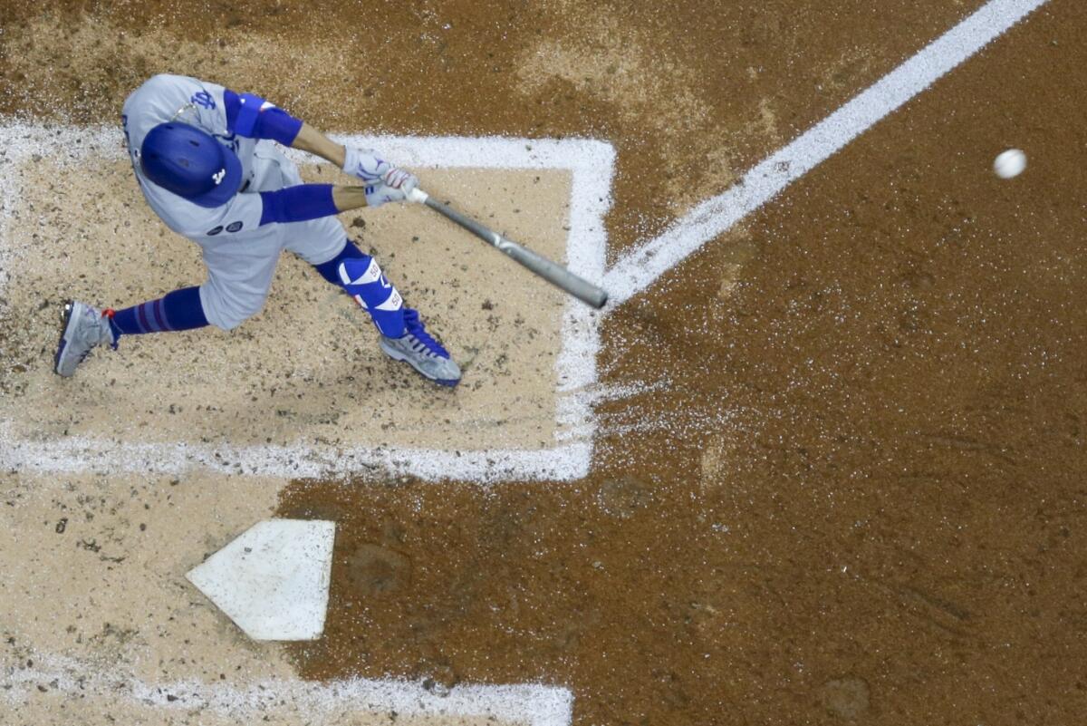 Dodgers center fielder Mookie Betts hits a single during the fifth inning of Saturday's loss to the Brewers.