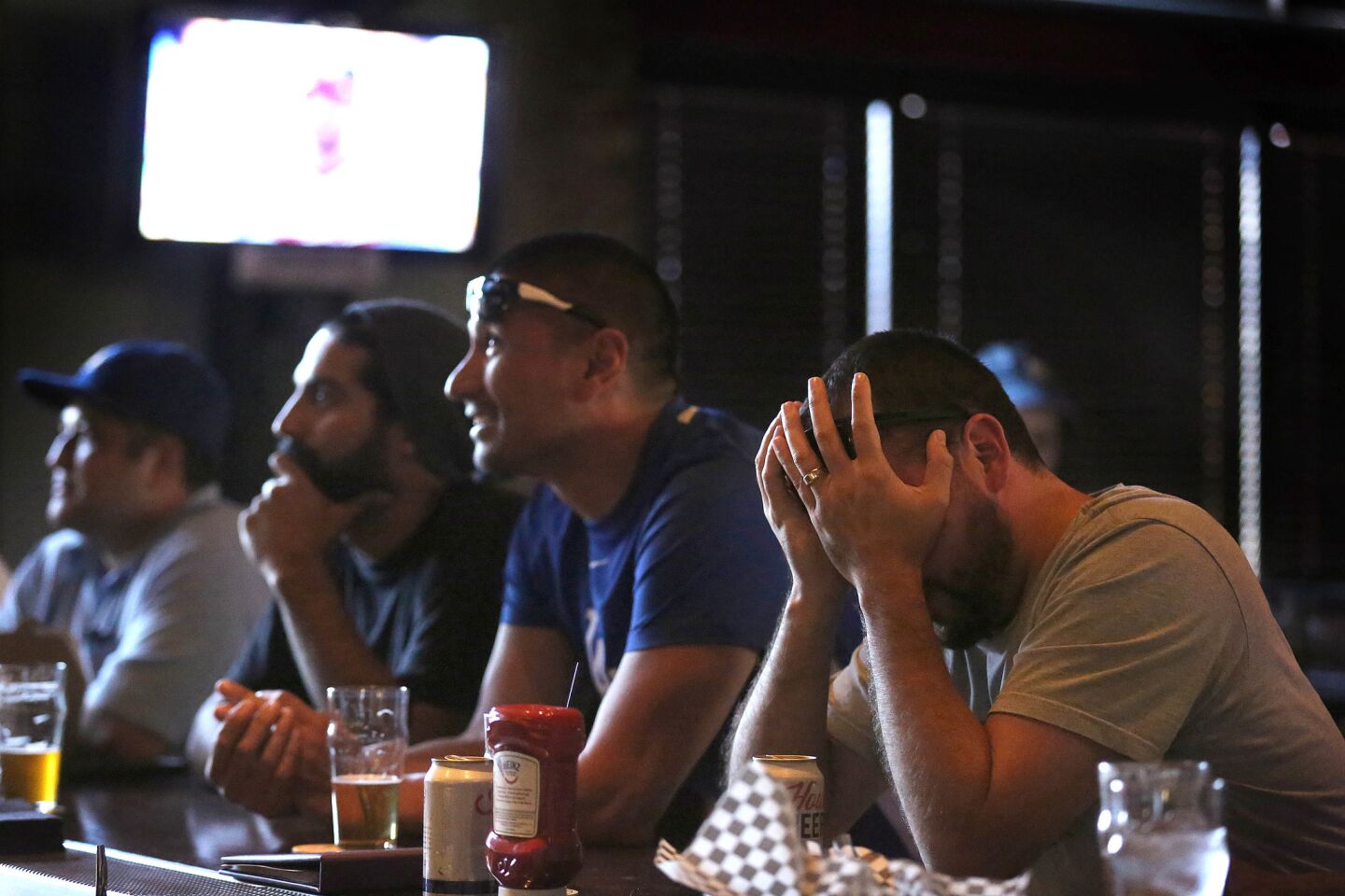 George Montejano, 33, of South Pasadena, can't bear to watch as the Dodgers temporariliy lose their lead against the Nationals.