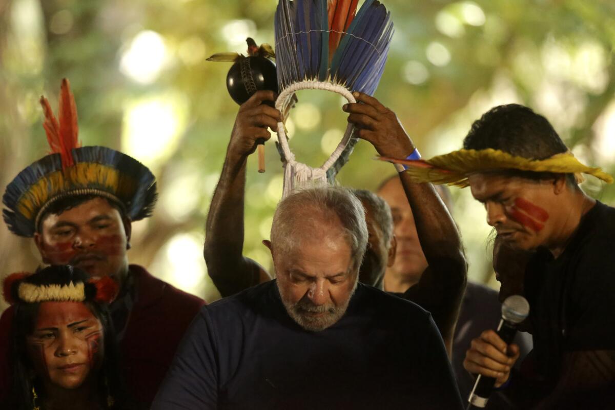 Brazil's Luiz Inacio Lula da Silva receiving a headdress from Indigenous people