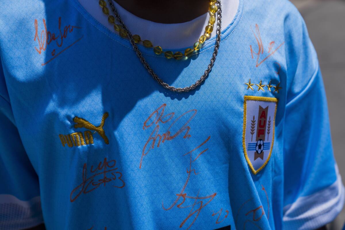 Una aficionado de Uruguay posa con una camiseta con autográfos de los jugadores de la selección 