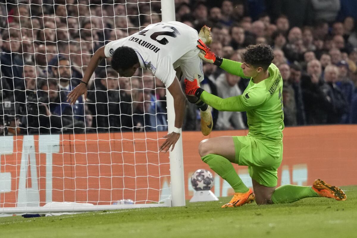 Rodrygo, del Real Madrid, izquierda, es derribado por el portero del Chelsea, Kepa Arrizabalaga, 