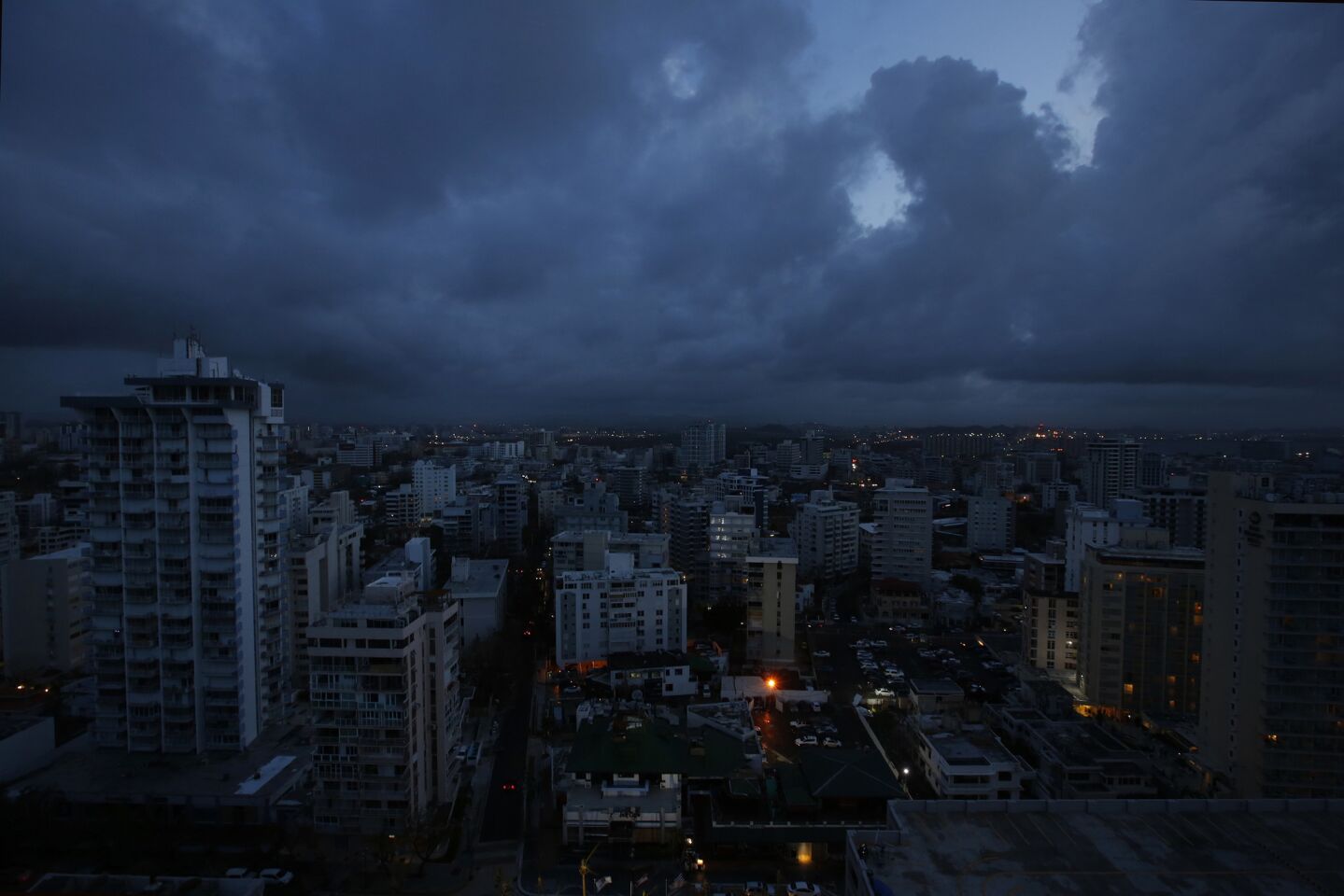 Darkness falls on downtown San Juan which remains without power. Puerto Rico officials say it will likely be four to six months before power is fully restored across the U.S. territory of 3.5 million people.