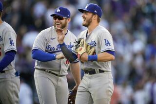 Los Angeles Dodgers second baseman Gavin Lux, front, and third baseman Max Muncy celebrate after the ninth inning of a baseball game against the Colorado Rockies Friday, April 8, 2022, in Denver. (AP Photo/David Zalubowski)