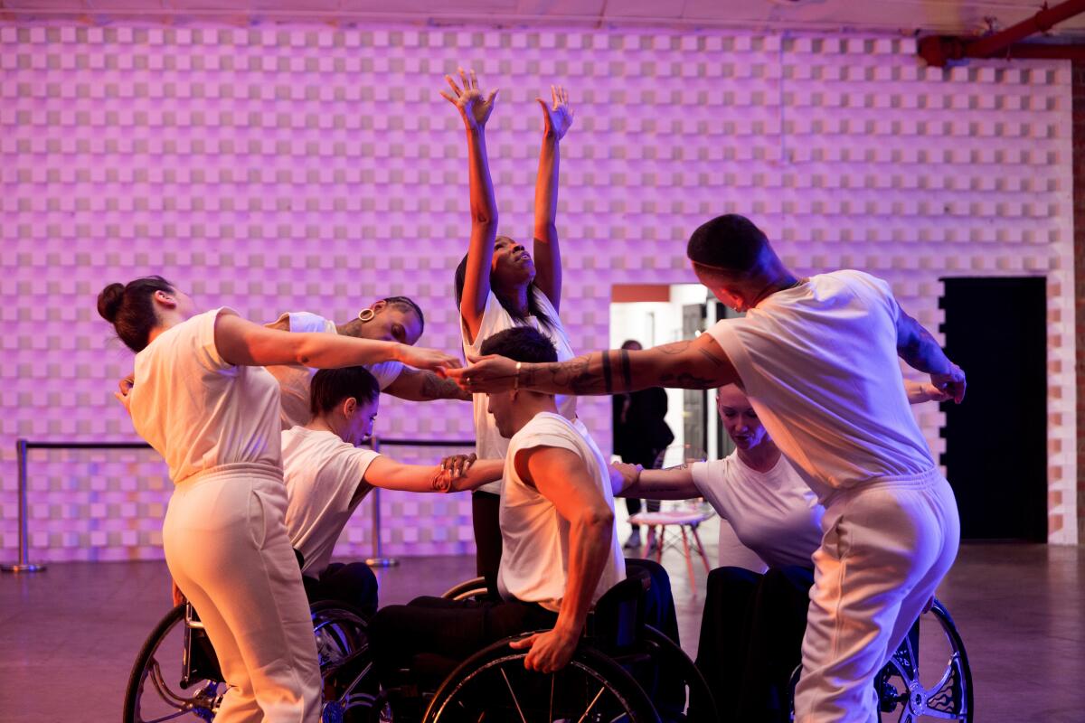Natalie Trevonne stands at the center of dancers forming a chain around dancers in wheelchairs.