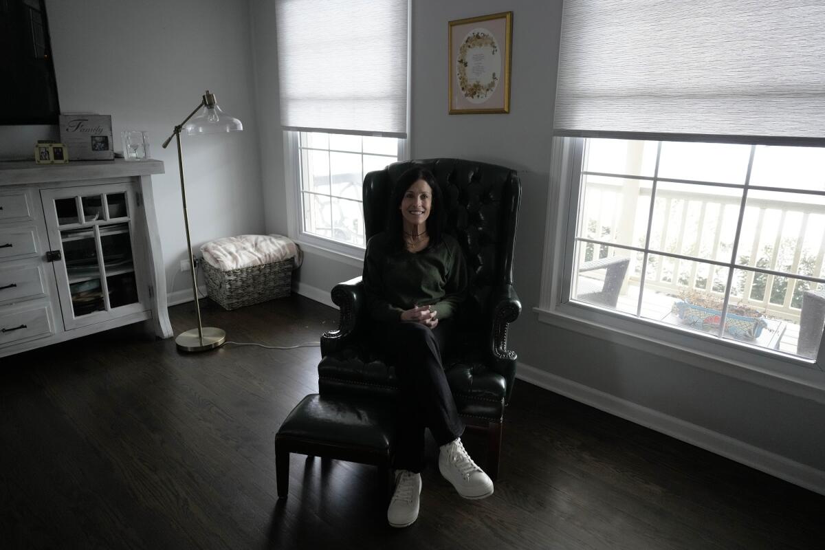 A JA cancer patient and advocate sits in a rocking chair at home.