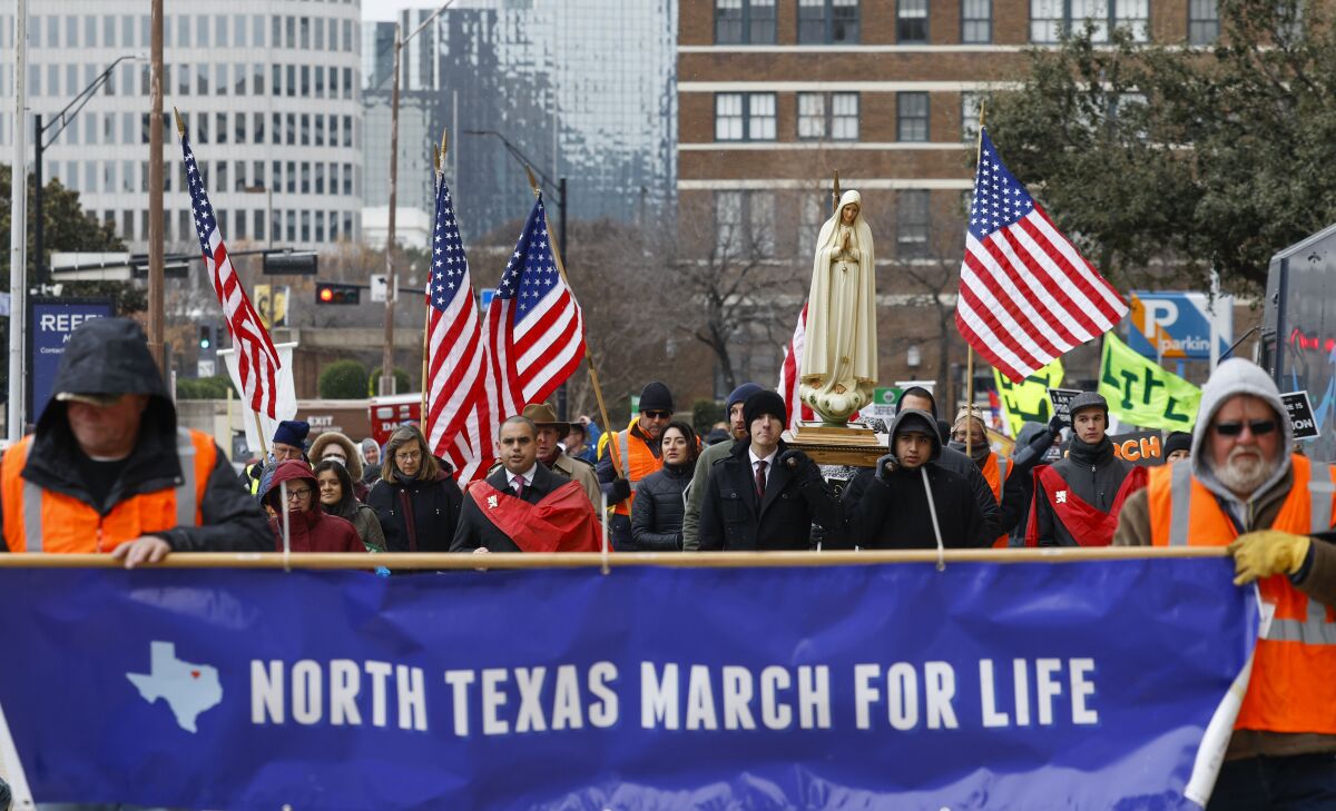 FILE - Protesters walk along Jackson St. during the North Texas March for Life, celebrating the passage and court rulings upholding the Texas law known as Senate Bill 8, on Saturday, Jan. 15, 2022, in Dallas. Abortions in Texas fell by 60% in the first month under the most restrictive abortion law in the U.S. in decades. That's according to the fist figures released by Texas health officials since the law known as Senate Bill 8 took effect in September. (Shafkat Anowar/The Dallas Morning News via AP)