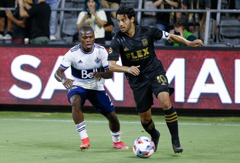 El delantero del LAFC, Carlos Vela, superó al mediocampista de los White Caps, Debre Caicedo, durante el partido de la temporada pasada.