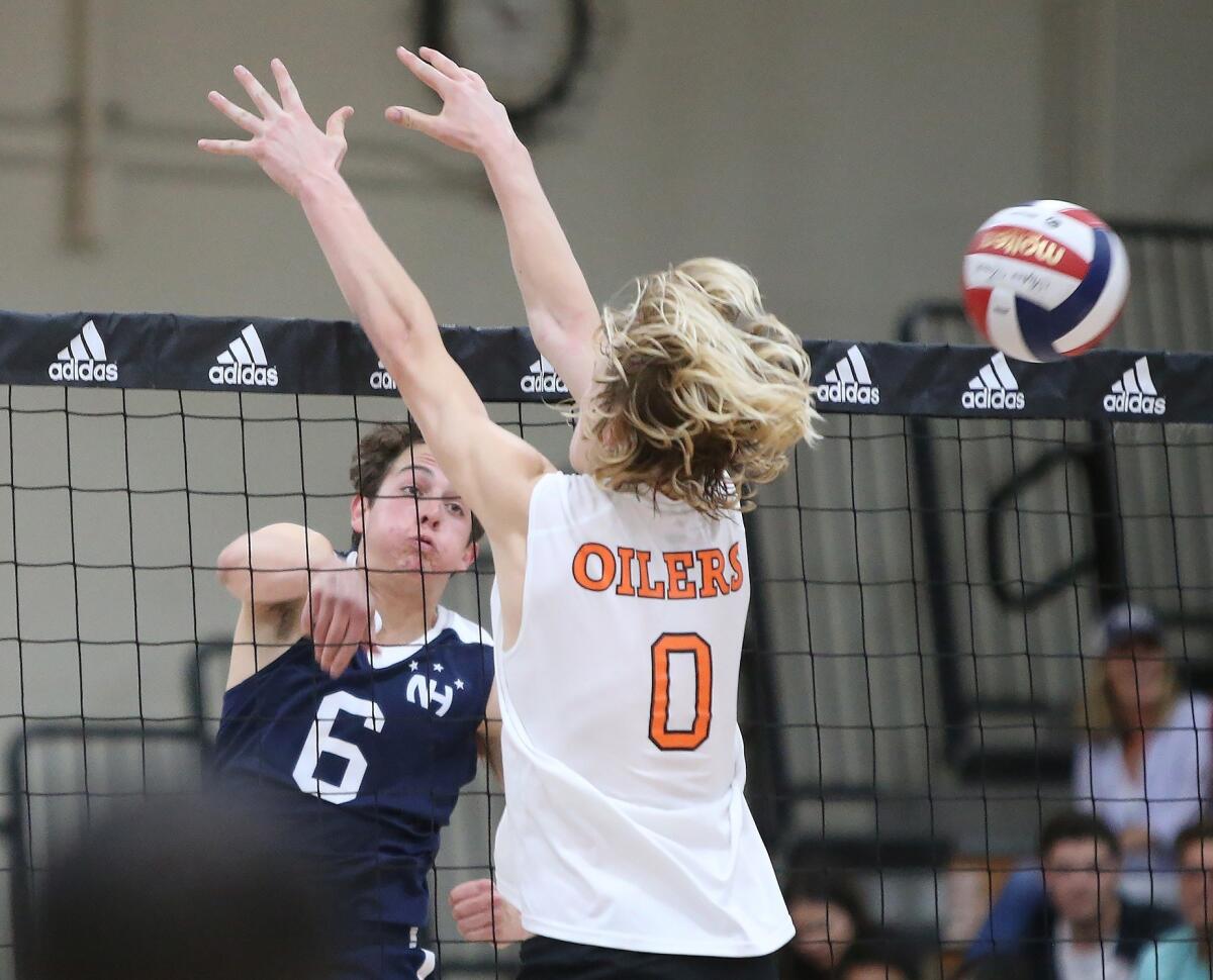Newport Harbor High's Blake Ludes (6) puts a short set away for a kill past Huntington Beach's Niko Colburn in a Surf League match on Friday.