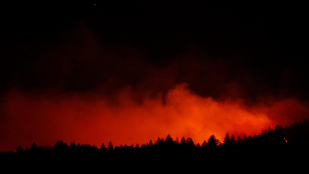 The Nuns fire crests over a line of trees as seen from Highway 29 north of Yountville on Oct. 13.