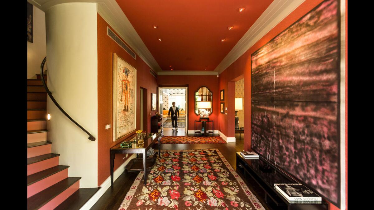 In the entryway, color, pattern and art combine to dramatic effect. On the left, a drawing by Jean-Michel Basquiat and right, a painting by L.A.-based artist Sterling Ruby. Dahan installed the low cabinets underneath the painting to add balance to the foyer.