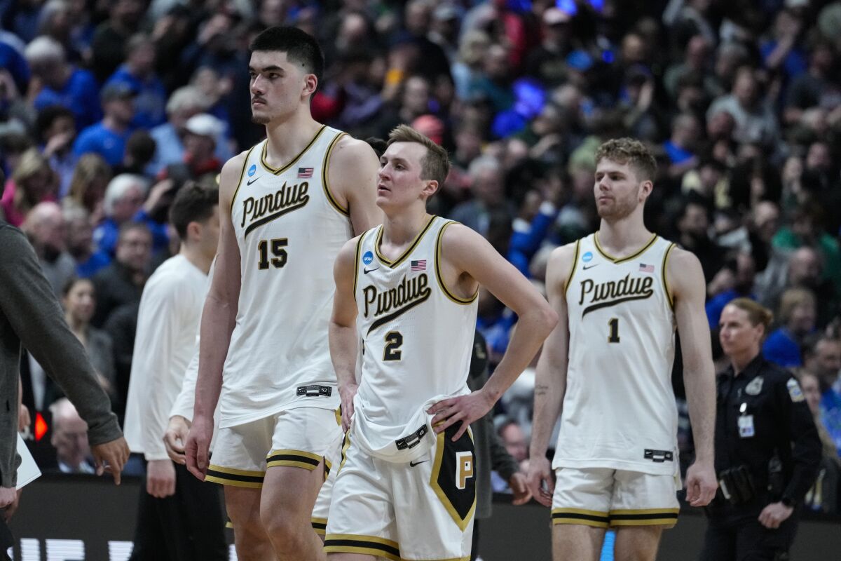 Purdue's Zach Edey (15), Fletcher Loyer (2) and Caleb Furst (1) walk off the court after losing to Fairleigh Dickinson.