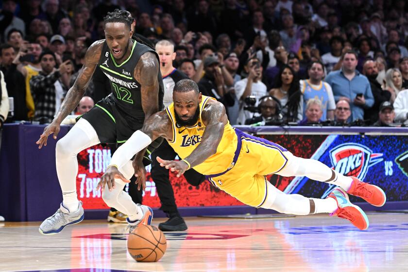 Los Angeles, California April 11, 2023-Lakers LeBron James dives for the ball in front of Timberwolves Taurean Prince after turning the ball over in the fourth quarter during a play-in game four the NBA playoffs at Crypto.com arena Tuesday. (Wally Skalij/Los Angeles Times)