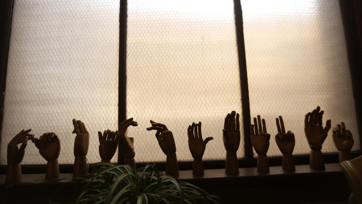 A row of mannequin hands rest on a window sill inside Lopez's loft.