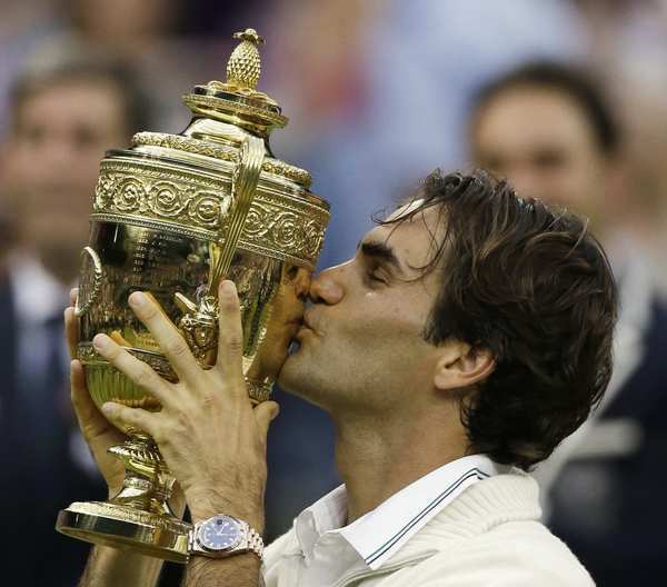 Roger Federer gives the winner's trophy a kiss during the awards ceremony following his victory over Andy Murray in the Wimbledon men's final on Sunday.