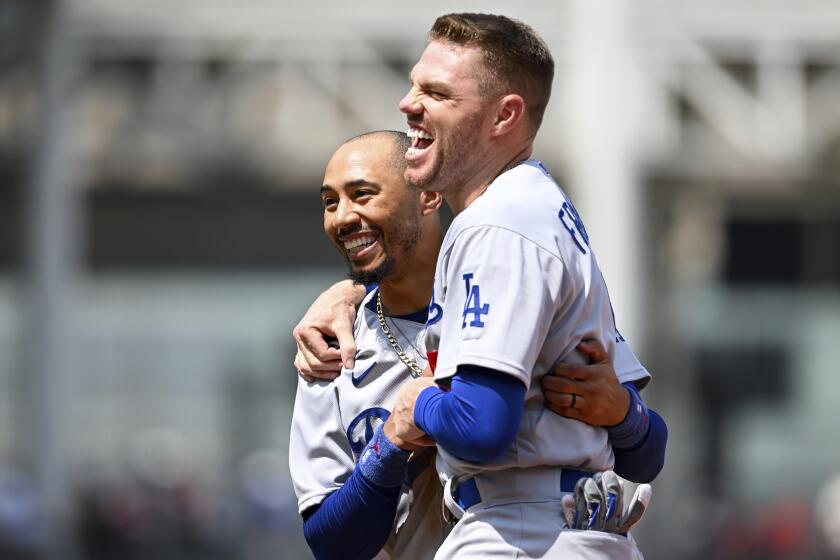 Los Angeles Dodgers' Mookie Betts, left, and Freddie Freeman laugh during the fourth inning in the continuation of a suspended baseball game against the Cleveland Guardians, Thursday, Aug. 24, 2023, in Cleveland. The game was suspended the night before due to inclement weather. (AP Photo/Nick Cammett)
