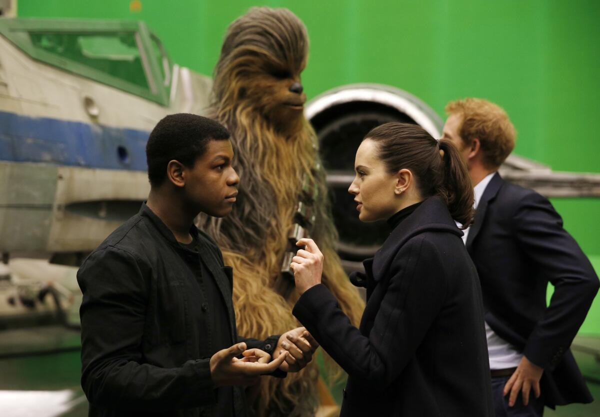 John Boyega and Daisy Ridley speak as Britain's Prince Harry meets with the character Chewbacca during a tour of the Star Wars sets at Pinewood Studios on April 19.