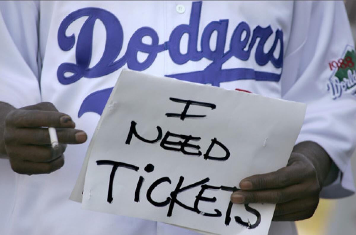 Scalper Cory Robertson holds a sign that is meant as a code to attract potential buyers.