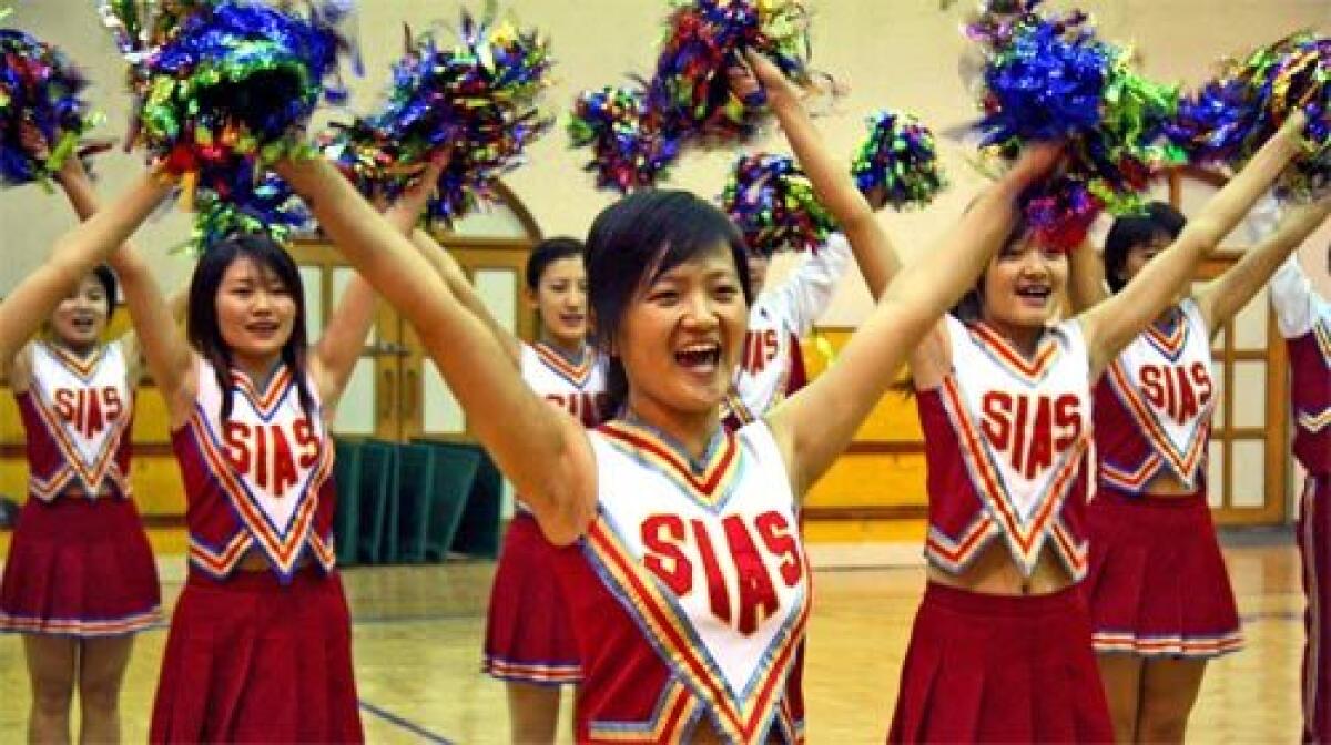 CHEERS: Bi Beibei, center, practices at school. Her team flew to the U.S. in May for the world cheerleading championships.