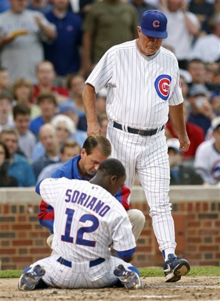 Chicago Cubs' Alfonso Soriano (12) is checked on by manager Lou Piniella, right, and trainer Mark O'Neil after getting hit by a pitch during the second inning of a baseball game against the Atlanta Braves on Wednesday, June 11, 2008, in Chicago. Soriano left Wednesday's game against Atlanta in the second inning after he was hit in the left hand by a pitch from Jeff Bennett. (AP Photo/Jerry Lai)