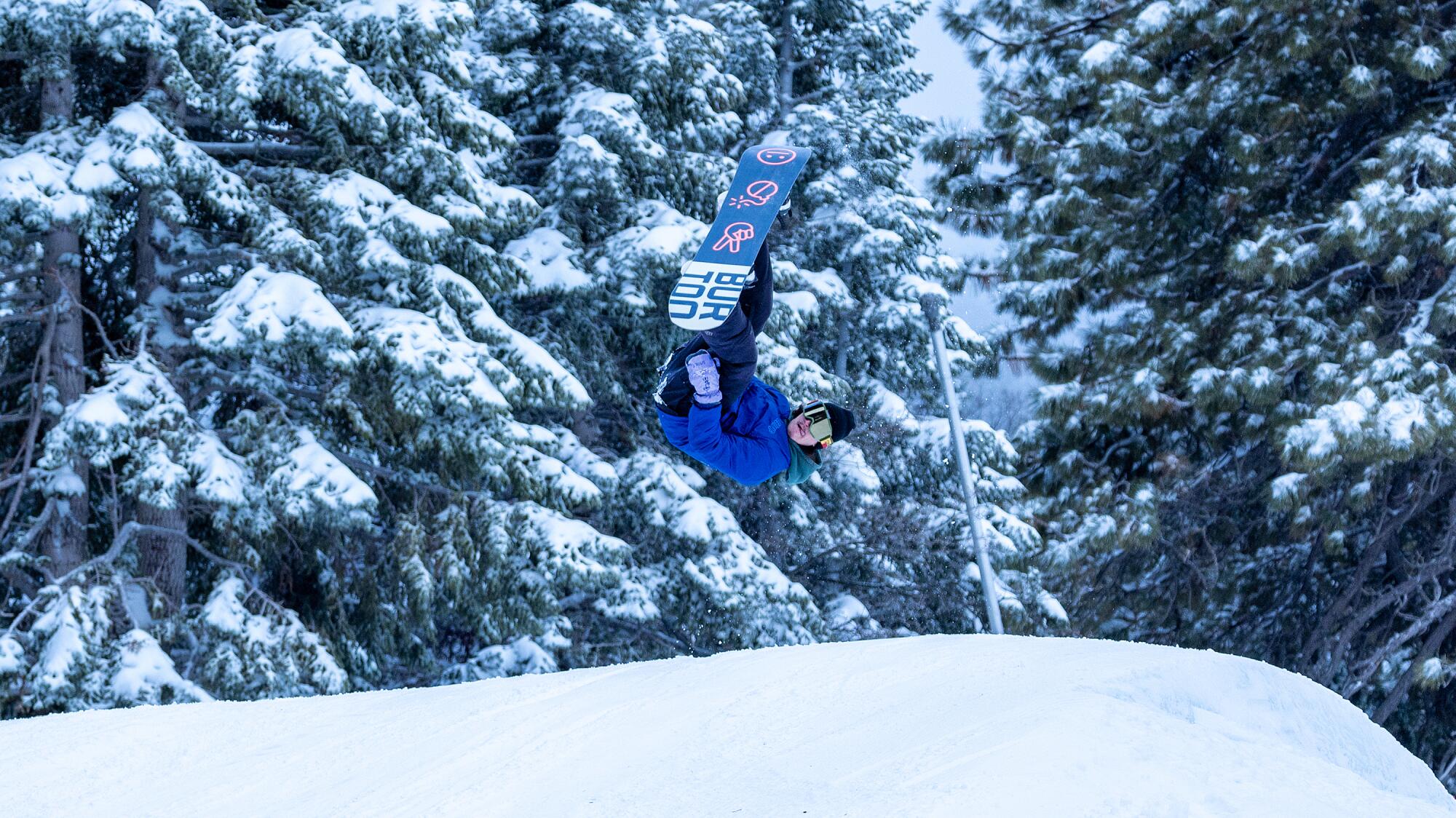A snowboarder takes flight off a jump.