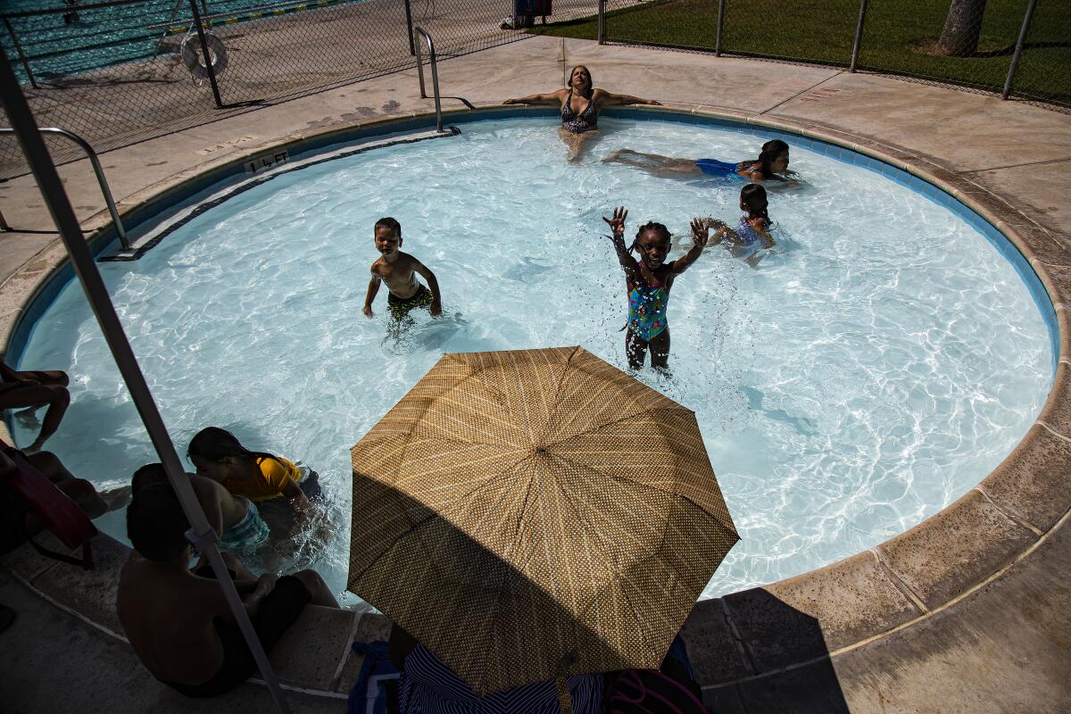 Adults and children cool off in the pool as the temperature tops 100 degrees Aug. 5 at Shamel Park Pool in Riverside.