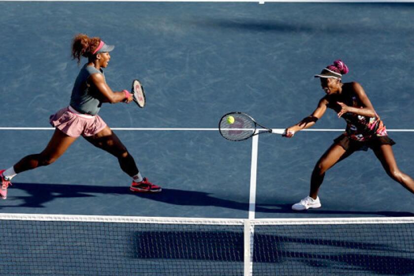 Venus Williams, teamed with her sister Serena, hits a forehand return during their third-round doubles victory against Anastasia Pavlyuchenkova and Lucie Safarova.