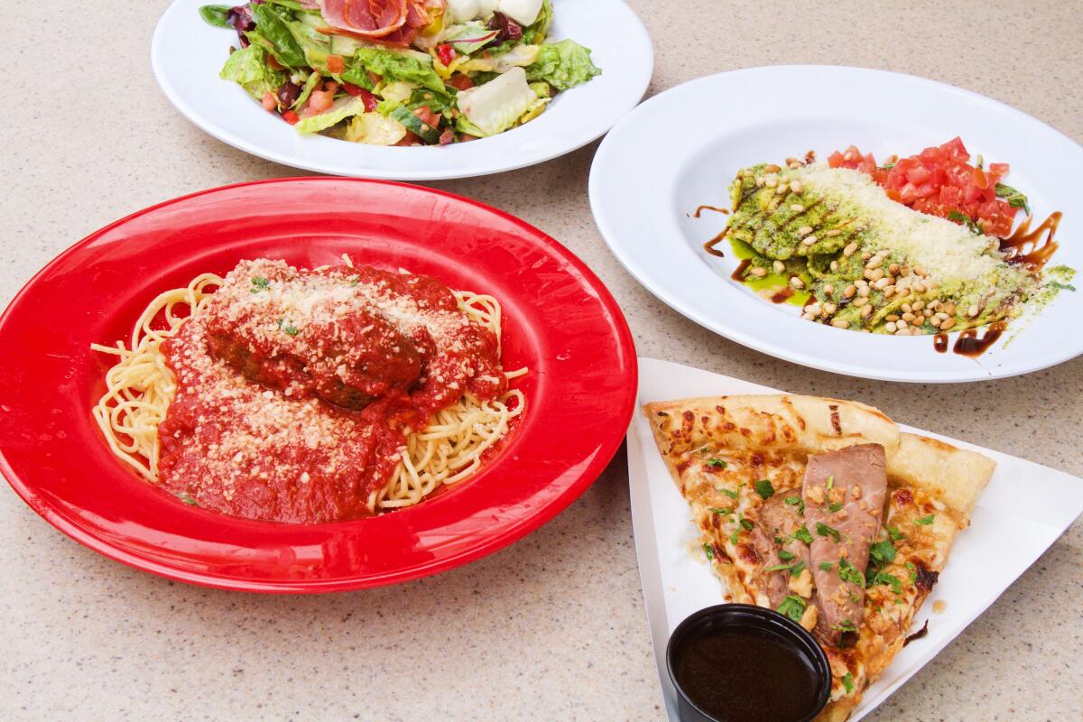 A photo of spaghetti in a red bowl, ravioli, a slice of pizza and an antipasto salad on bowls and plates