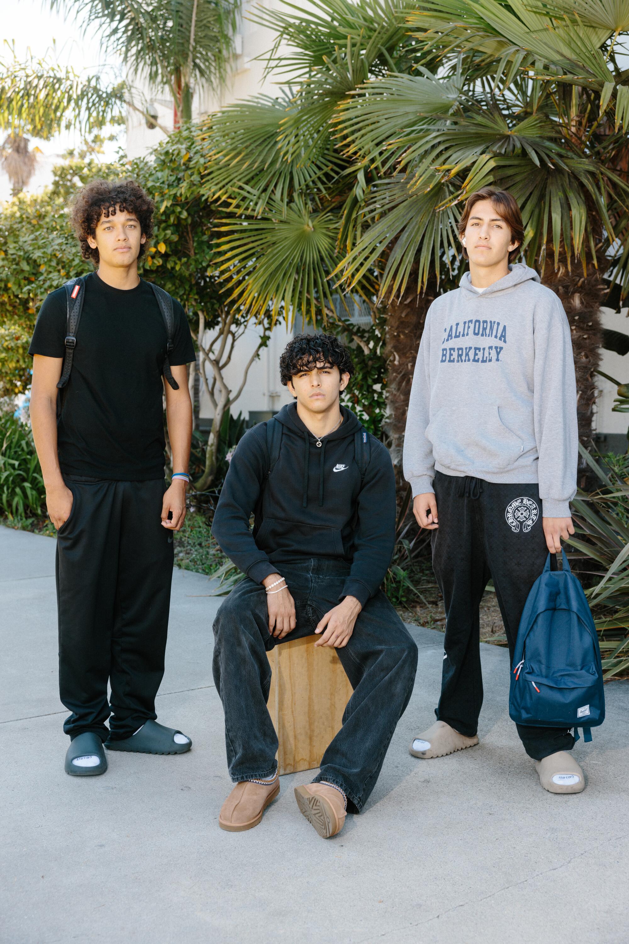 Three boys posing for a portrait in casual outfits.